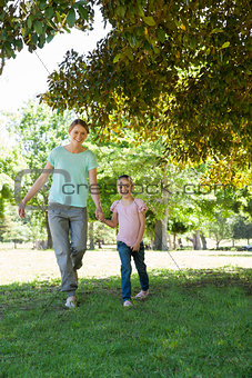 Happy mother and daughter walking at park