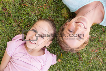 Portrait of mother and daughter lying on grass at park