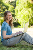 Relaxed woman using laptop at park