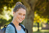 Beautiful young woman with backpack at park