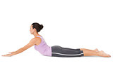 Side view of a fit young woman doing the cobra pose