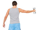 Rear view of a young man holding out dumbbell