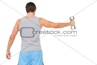 Rear view of a young man holding out dumbbell