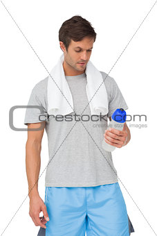 Fit young man with water bottle and towel