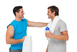 Happy fit young men with water bottle and towels
