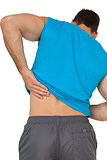 Rear view of man in sportswear suffering from backache