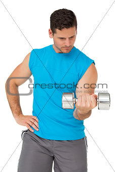 Fit young man exercising with dumbbell