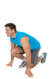 Side view of a sporty smiling man in running stance