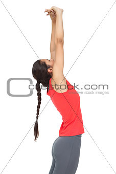 Side view of a sporty young woman stretching hands