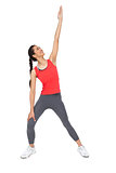Full length of a sporty young woman stretching hand