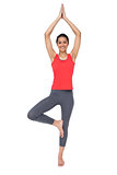 Full length of a fit smiling woman standing in tree pose
