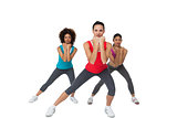 Full length portrait of women doing power fitness exercise