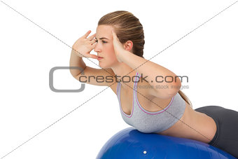 Fit young woman stretching on fitness ball