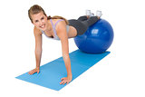 Portrait of a fit woman stretching on fitness ball
