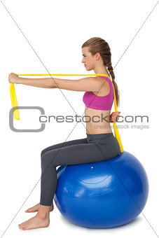 Full length of a fit woman exercising on fitness ball