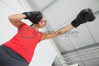 Determined female boxer focused on training at gym