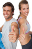 Portrait of a sporty young couple gesturing thumbs up