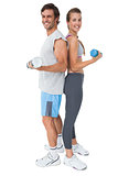 Portrait of a fit couple exercising with dumbbell