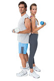 Portrait of a fit young couple exercising with dumbbell