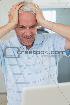 Stressed man using his laptop