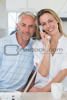 Happy man listening in on his blonde partners phone call