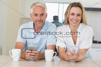 Happy couple sitting at the counter texting