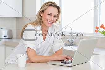 Happy woman using laptop at counter