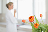Woman looking out window with focus on tulips