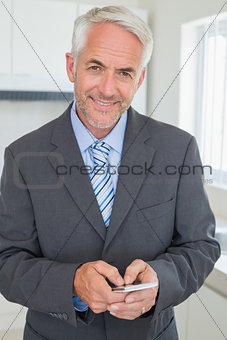 Happy businessman texting in the morning before work
