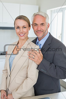 Happy business couple smiling at camera before work in morning