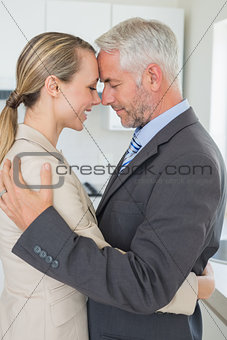 Happy business couple hugging each other before work in morning