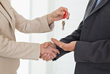Estate agent giving house key to customer