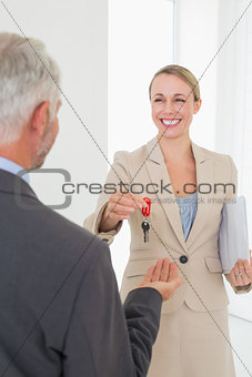Estate agent giving house key to happy customer