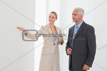 Smiling estate agent showing room to potential buyer