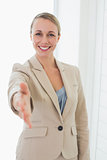 Smiling estate agent holding her hand out to camera