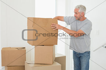 Smiling man looking at cardboard moving boxes