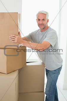 Happy man moving cardboard moving boxes