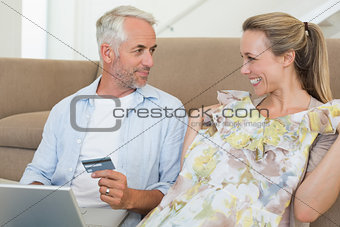 Happy couple shopping online on the couch