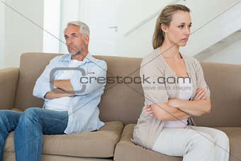 Angry couple sitting on couch not talking to each other