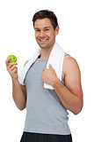 Portrait of a smiling fit young man with apple standing