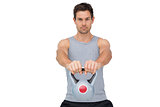 Portrait of a young man exercising with kettle bell