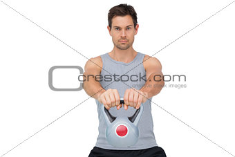 Portrait of a young man exercising with kettle bell
