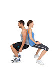 Side view of a fit young couple doing squats