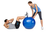 Female trainer assisting man with exercises