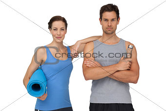 Portrait of a fit couple with exercise mat and water bottle