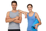 Fit young couple with exercise mat and water bottle