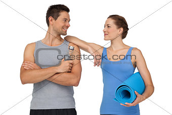 Fit young couple with exercise mat and water bottle