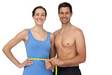 Fit young man measuring womans waist