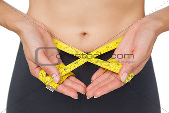 Close-up mid section of a woman measuring waist