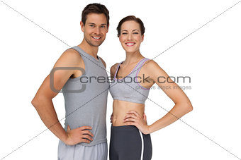 Portrait of a happy fit couple with hands on hips